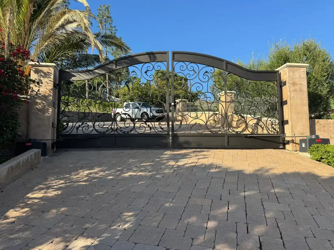 Custom wrought iron driveway gate installed in front of a Southern California home