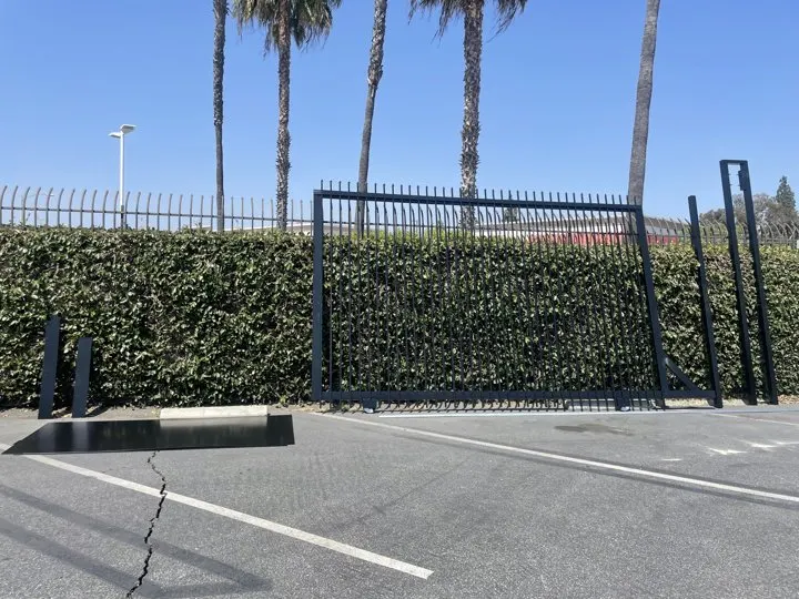 Tall open mesh fence above the planted boundary