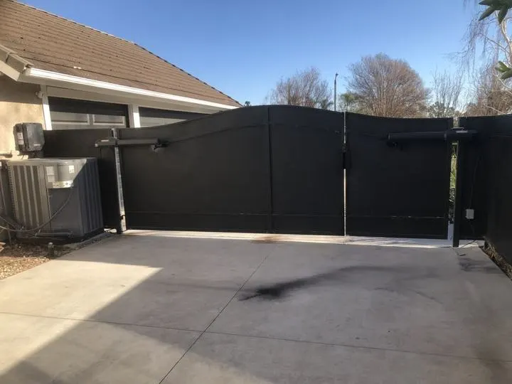Curved, screened double driveway gate in the closed position.