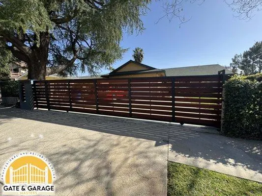 Wide horizontal timber-style driveway gate.