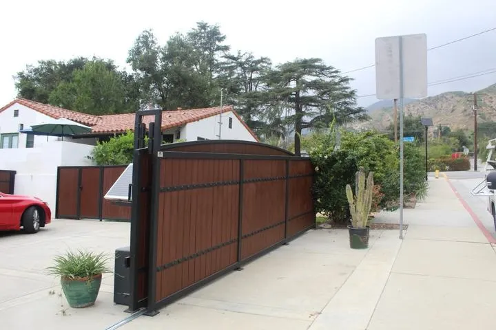 Arched driveway gate shown open