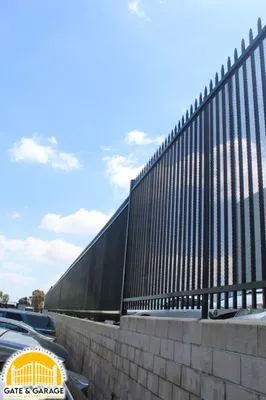 Open picket fencing above a masonry wall.